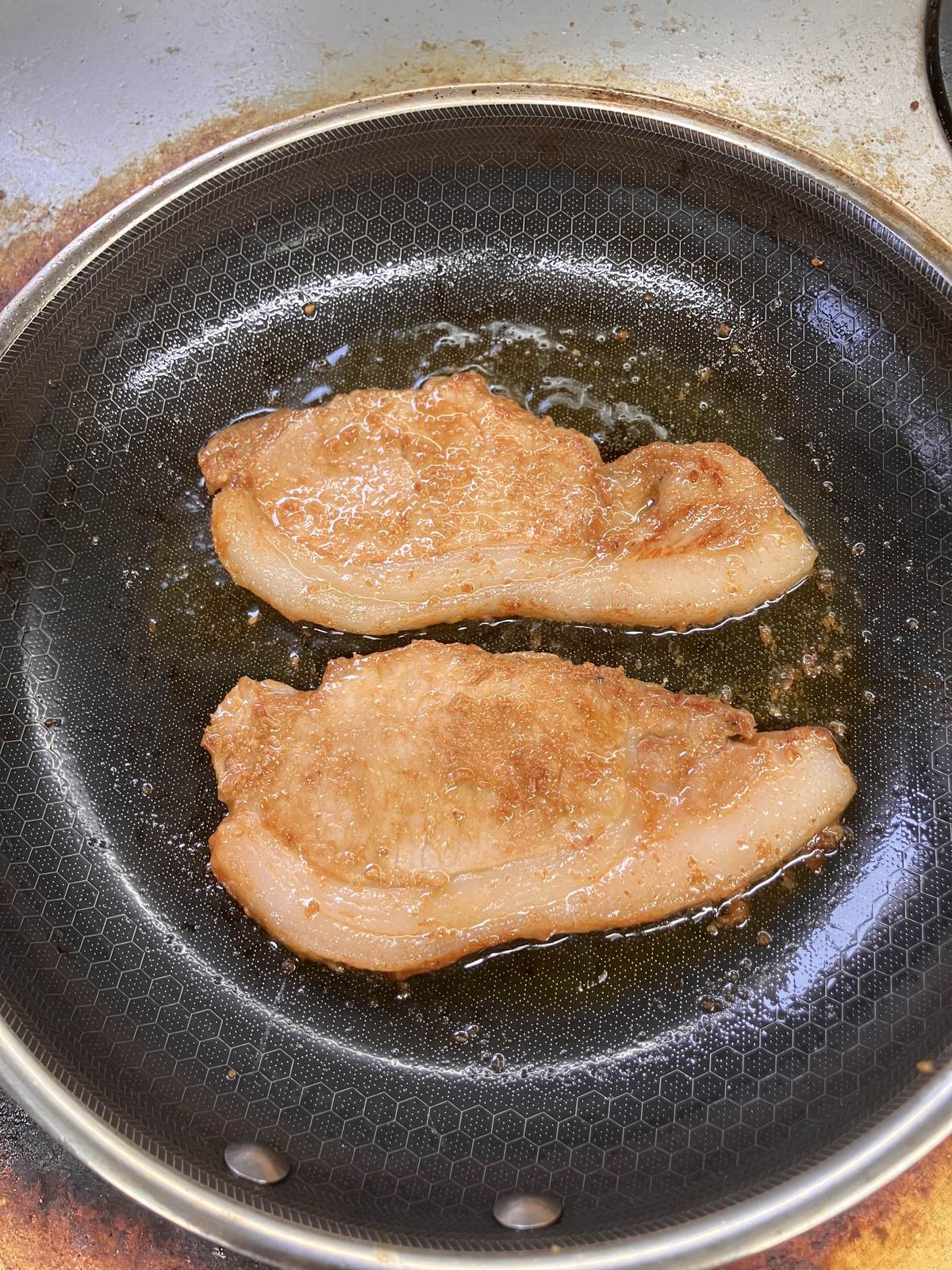 フライパンで麓山高原豚の味噌漬けを焼いている様子